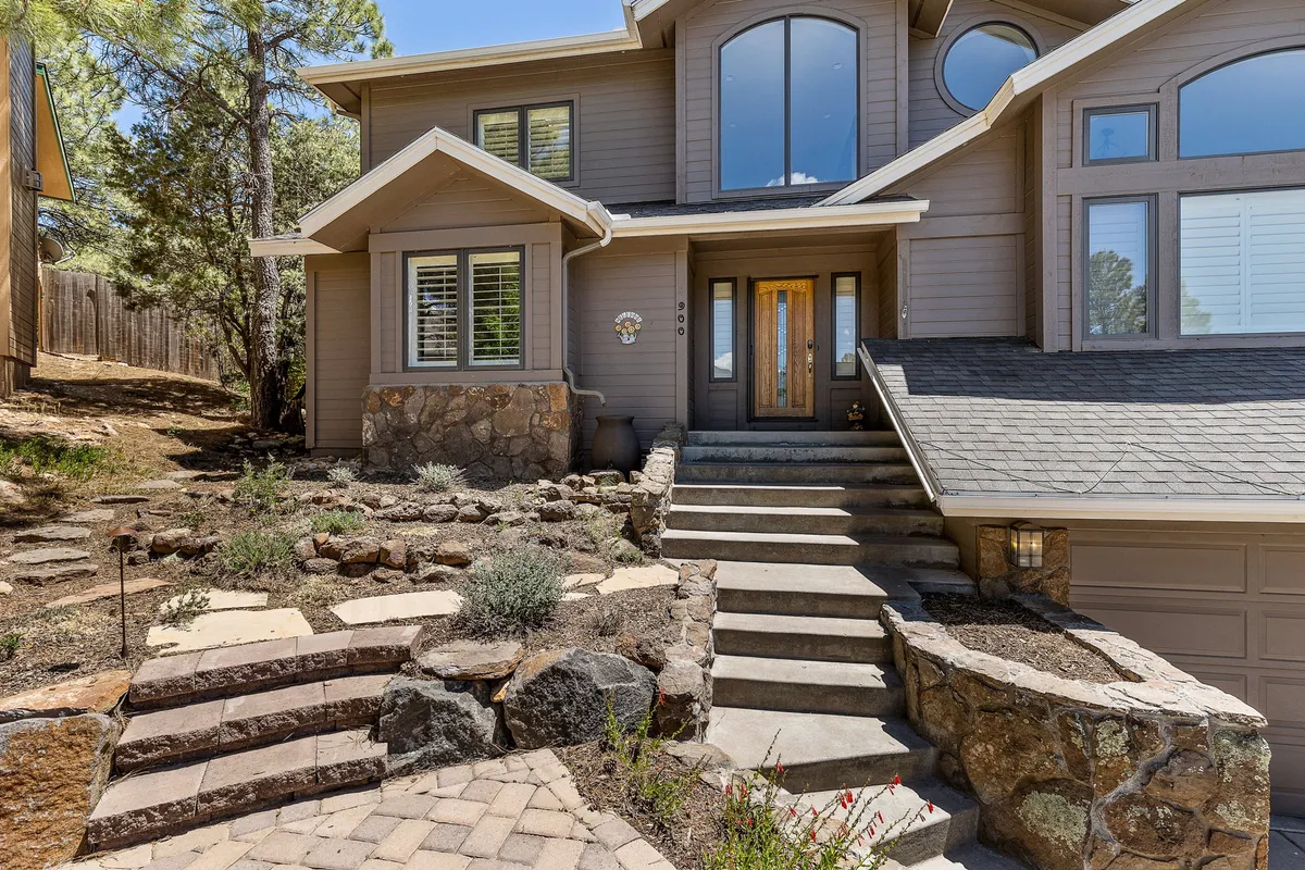 The front entrance of the property features stone steps, a landscaped garden, and a welcoming exterior. It’s an open, accessible space ideal for coming and going with pets, and for enjoying the scenic setting.